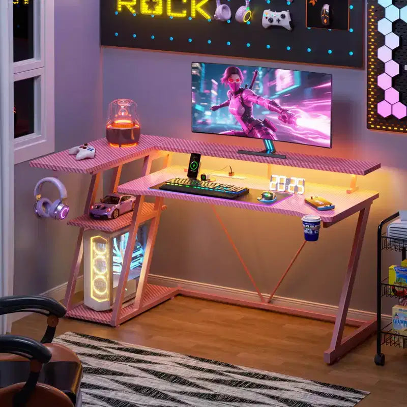 Bureau de jeu d'angle en L rose avec support d'écran et 3 étagères de rangement, bureau de joueur moderne en fibre de carbone pour un gain de place