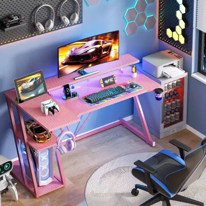 Bureau de jeu d'angle en L rose avec support d'écran et 3 étagères de rangement, bureau de joueur moderne en fibre de carbone pour un gain de place